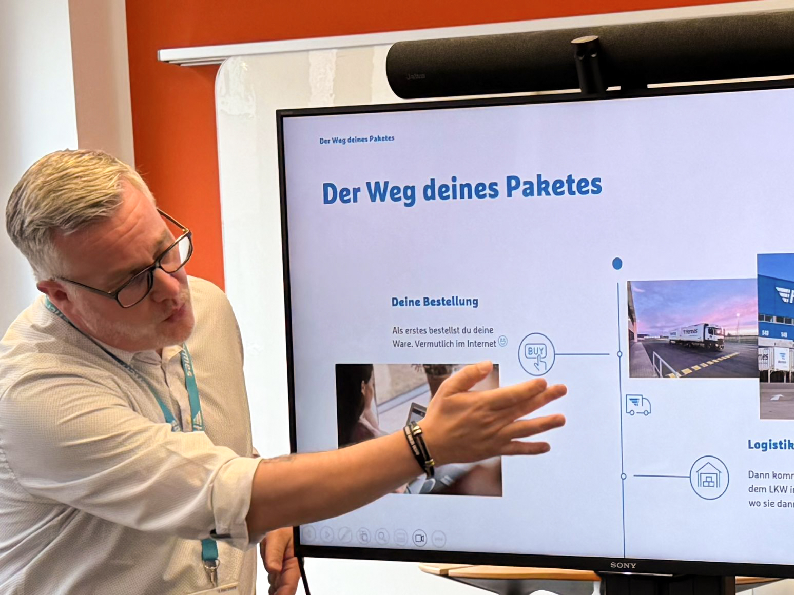 Ein Kollege aus dem Customer Service zeigt den Kindern den Weg des Paketes. 